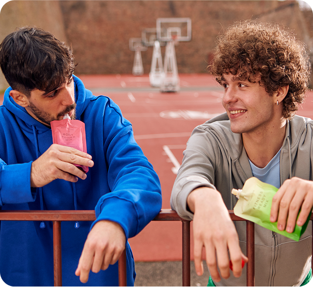 Snacking rituals two young men on a basketball court smiling holding Root Power Mix Fitness Ready